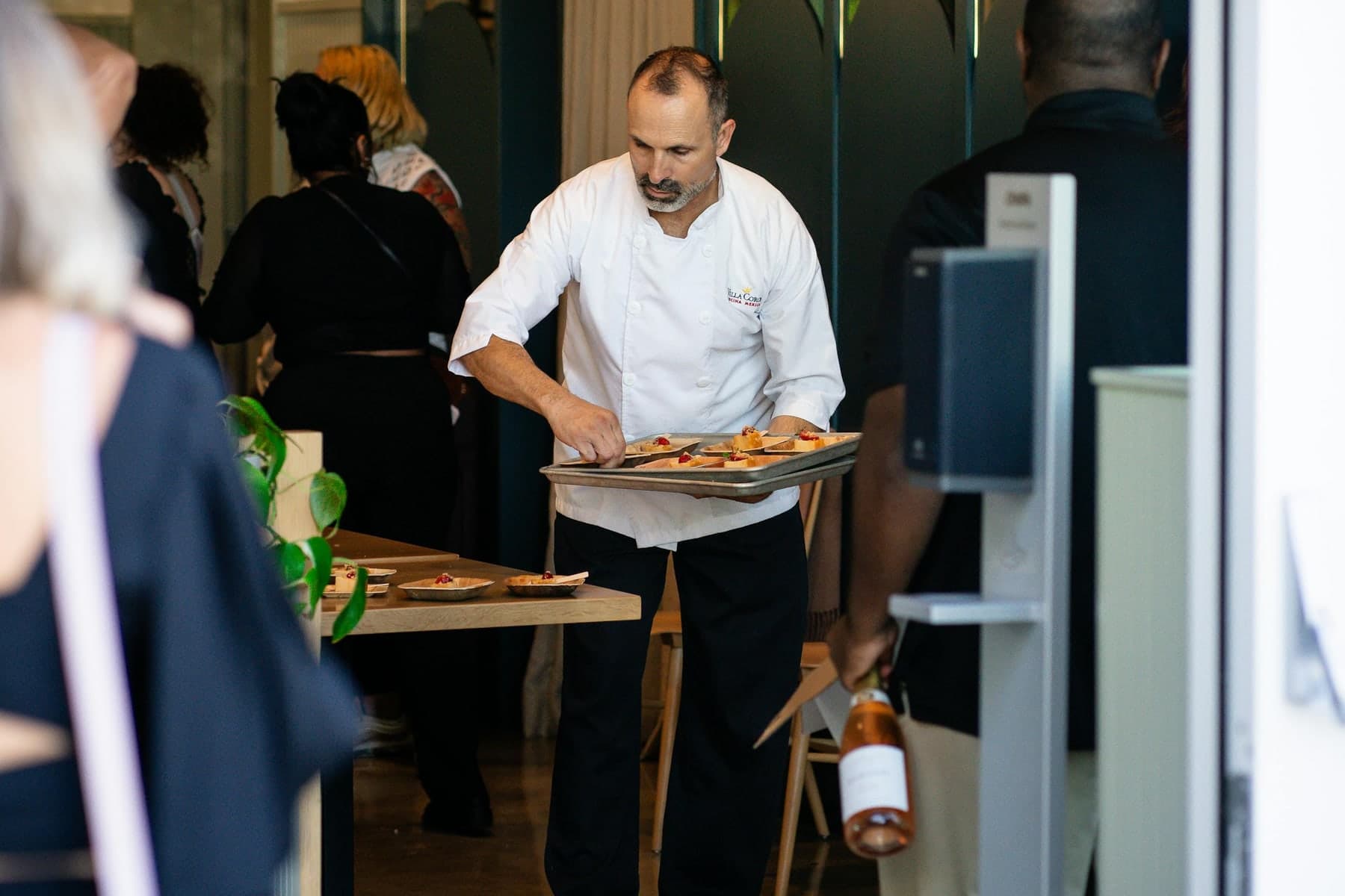 Server carrying plated dishes through a full-service dining room