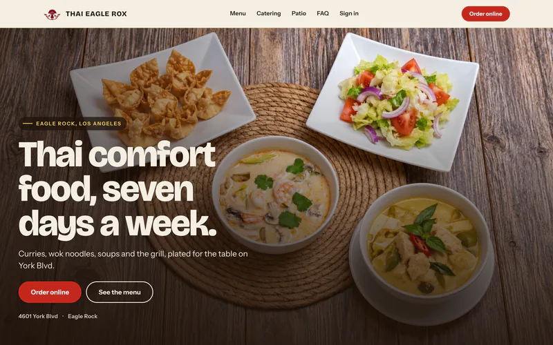 Thai Eagle Rox’s website: “Thai comfort food, seven days a week.” over curries, salad and wontons on a wooden table.