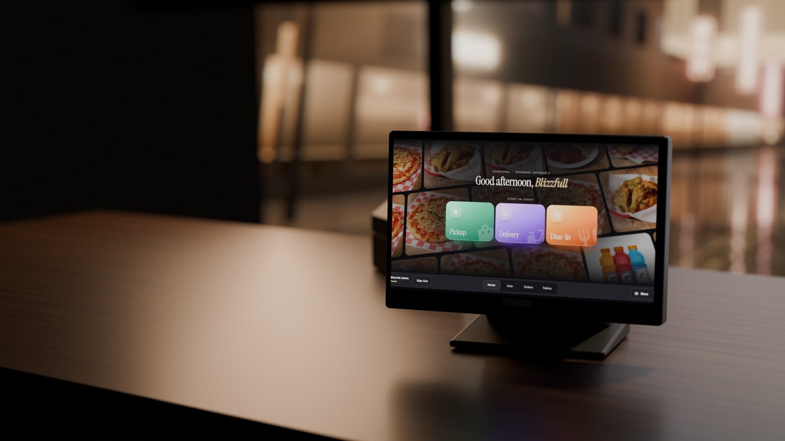 The Blizzfull POS on a walnut counter after close, its Cinematic home screen lit, the street out of focus behind.