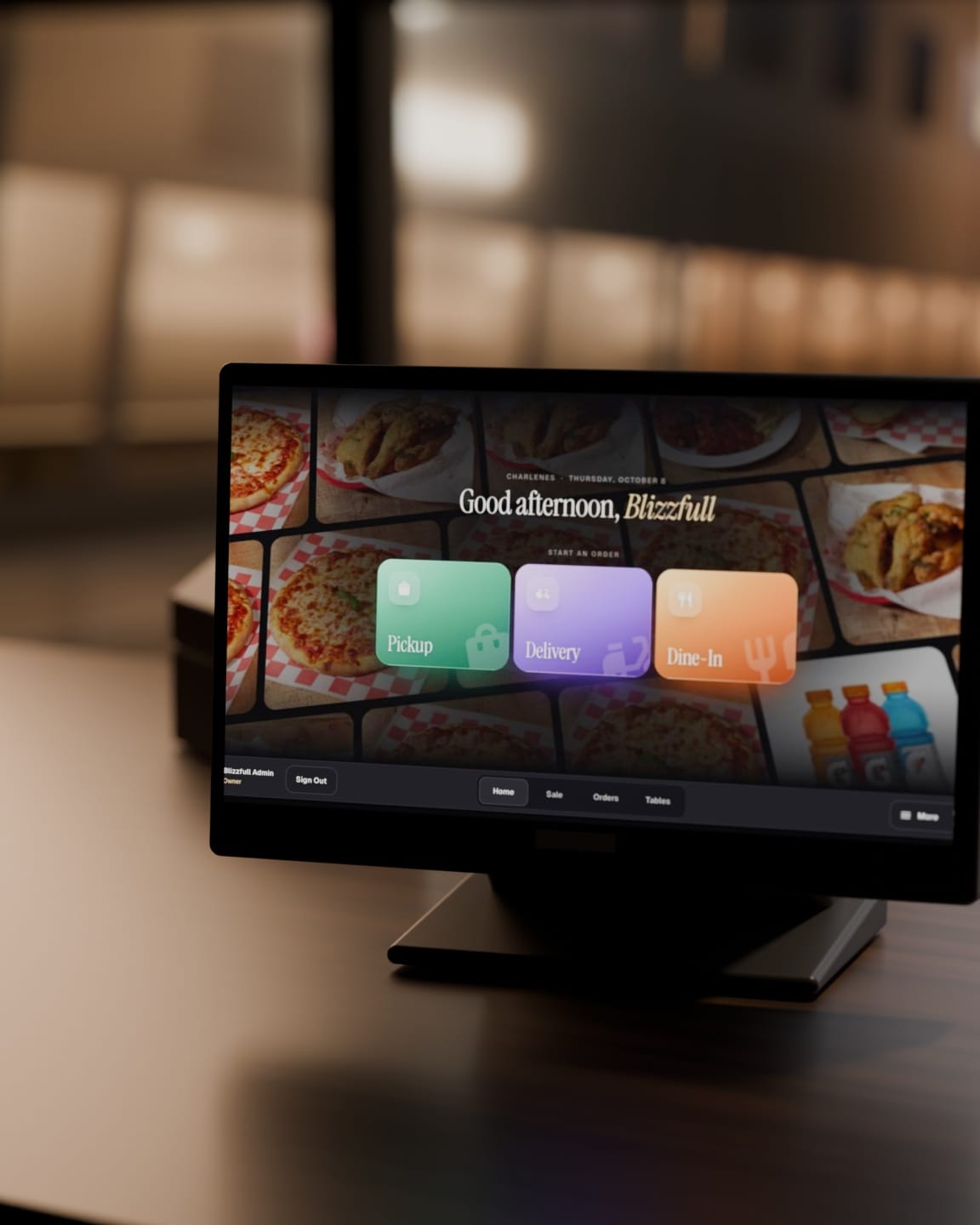 The Blizzfull POS on a walnut counter after close, its home screen lit and the street out of focus behind. Illustration rendered for this site.